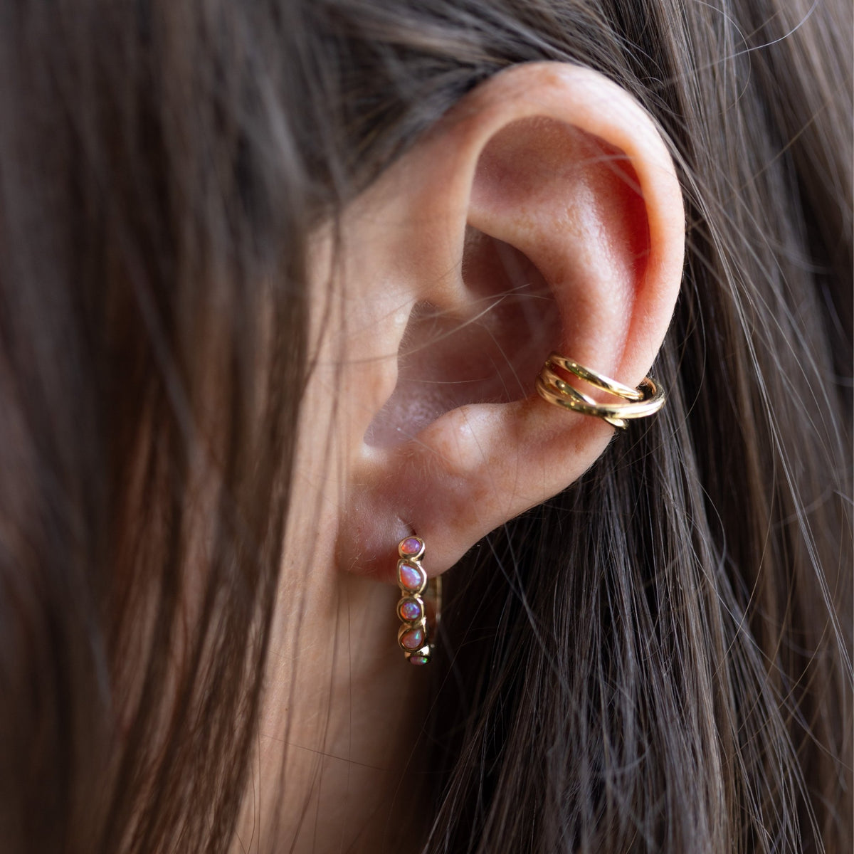 A sculptural statement for your ear stack. The Entwine Cuff features fluid, interlocking curves that create the look of layered metal—no piercing required. **Materials:** Gold-plated brass - Decollective -  - 